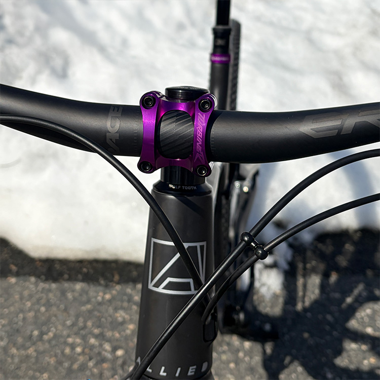 Close up of top tube and handlebar on Allied with purple accents.