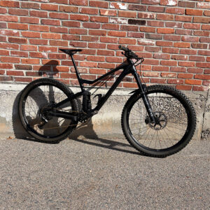 Side view of black SCOTT Genius against a brick wall.