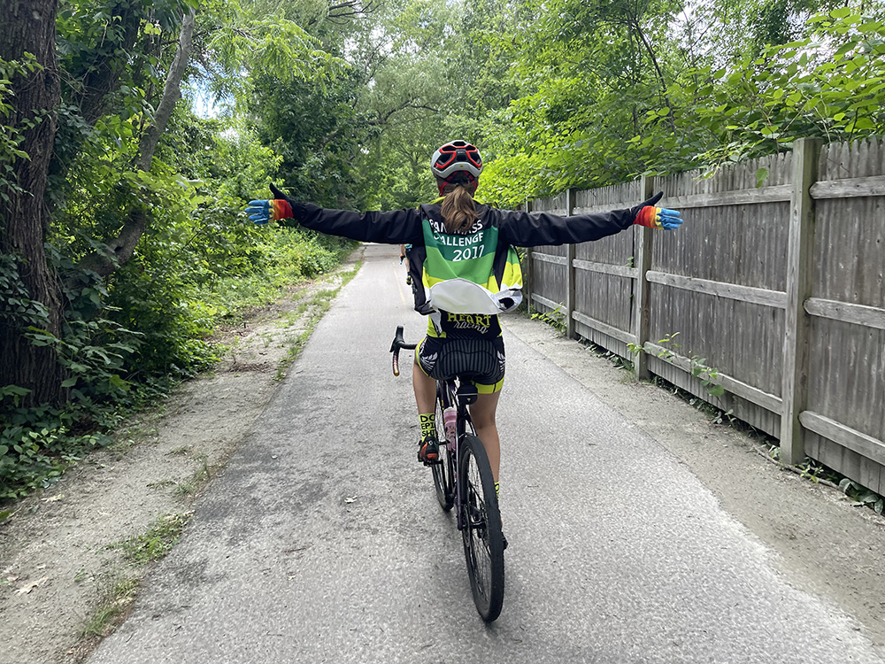 A rider, pictured from behind, riding with no hands.
