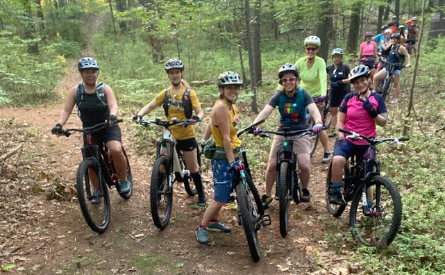 Group of women riding in the woods.
